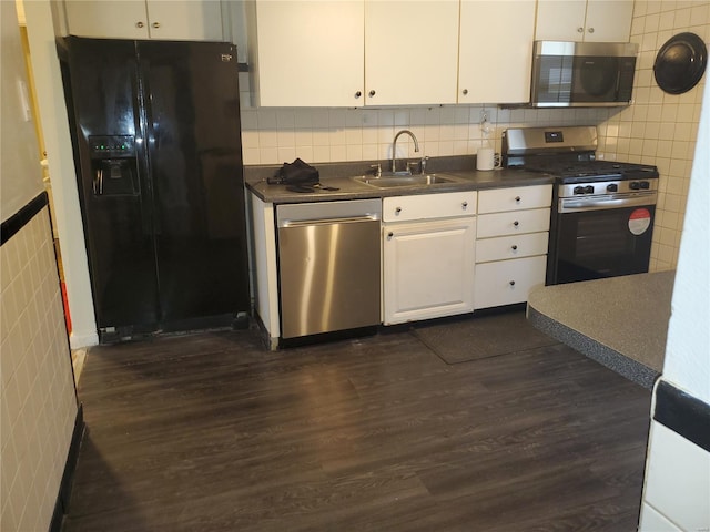 kitchen with a sink, dark countertops, stainless steel appliances, and dark wood finished floors