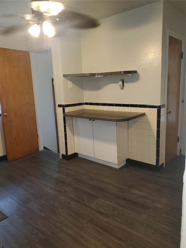 kitchen featuring white cabinets, ceiling fan, dark countertops, open shelves, and dark wood-type flooring