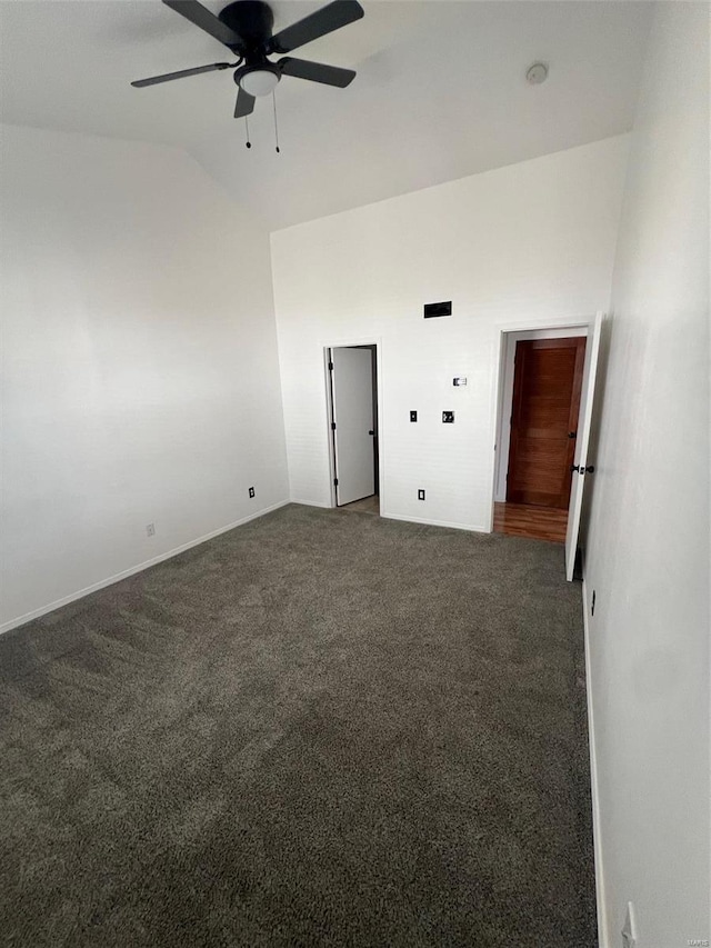 carpeted spare room with ceiling fan and vaulted ceiling