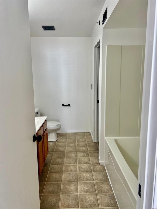 bathroom with tile patterned floors, toilet, a washtub, and vanity