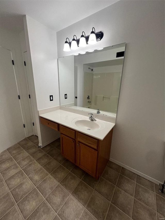 bathroom with tile patterned floors, vanity, and a shower