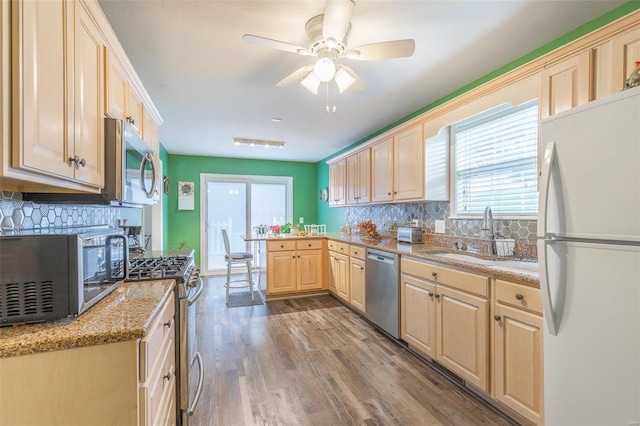 kitchen with ceiling fan, backsplash, hardwood / wood-style flooring, stainless steel appliances, and light brown cabinetry