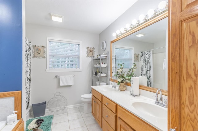 bathroom with vanity, toilet, tile patterned floors, and a wealth of natural light