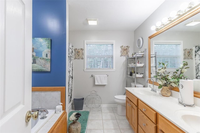 bathroom featuring a tub to relax in, vanity, toilet, and tile patterned floors