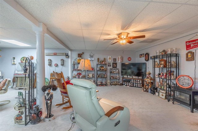 living room with decorative columns, ceiling fan, carpet floors, and a paneled ceiling