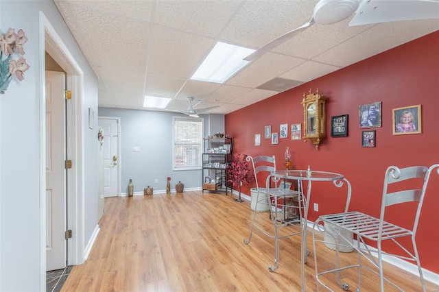 interior space with a paneled ceiling and hardwood / wood-style flooring