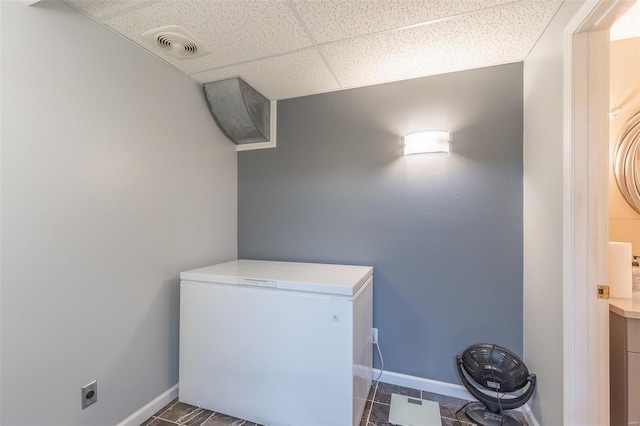 laundry area with dark tile patterned flooring