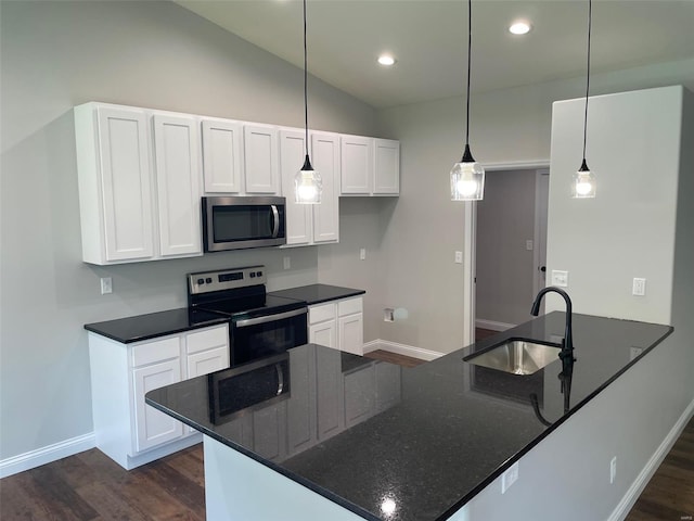 kitchen with dark wood-style flooring, a sink, white cabinets, appliances with stainless steel finishes, and dark stone counters