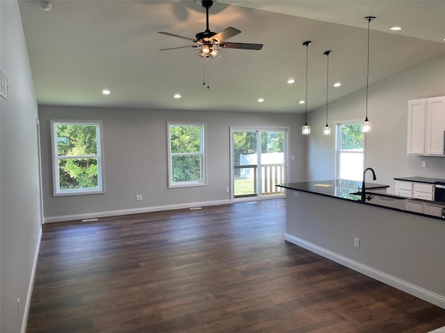 kitchen with sink, white cabinetry, decorative light fixtures, vaulted ceiling, and dark hardwood / wood-style floors