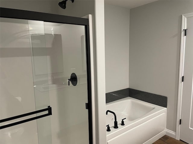 bathroom with plus walk in shower and hardwood / wood-style floors