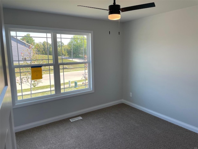 carpeted spare room featuring ceiling fan