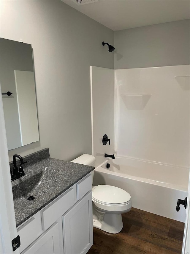 full bathroom featuring vanity, hardwood / wood-style floors, shower / tub combination, and toilet