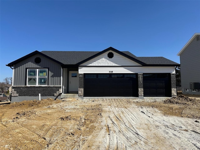 view of front of house with an attached garage, board and batten siding, and brick siding