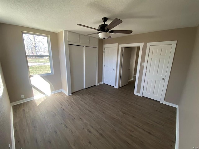 unfurnished bedroom featuring a textured ceiling, dark hardwood / wood-style floors, and ceiling fan