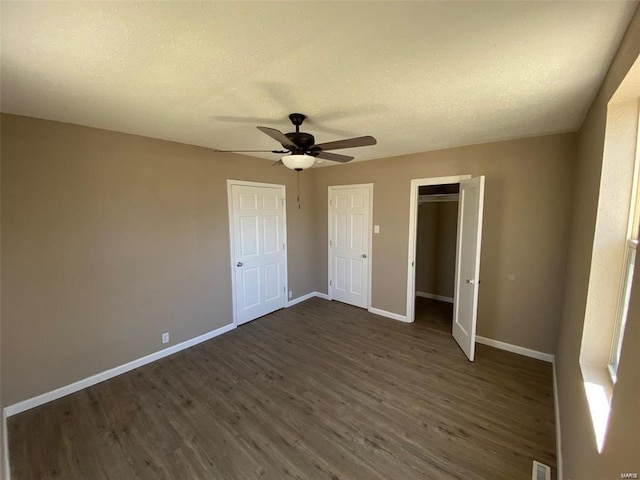 unfurnished bedroom featuring a textured ceiling, dark hardwood / wood-style flooring, and ceiling fan