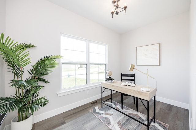 home office with dark hardwood / wood-style flooring and a chandelier