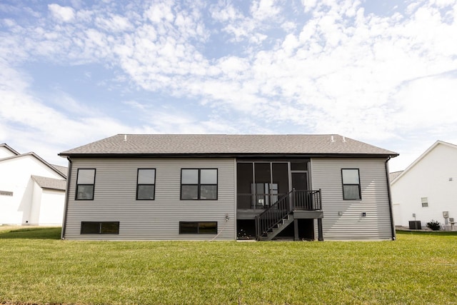 back of house featuring cooling unit, a sunroom, and a lawn