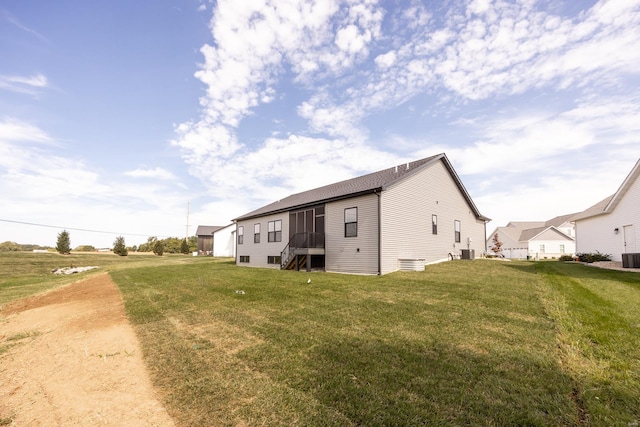 rear view of house with a lawn and cooling unit