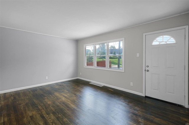 entrance foyer with ornamental molding, plenty of natural light, and dark hardwood / wood-style flooring