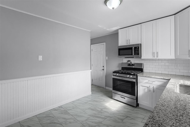 kitchen featuring light stone countertops, appliances with stainless steel finishes, backsplash, and white cabinetry