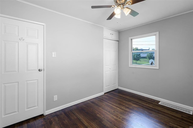 unfurnished room with ceiling fan, ornamental molding, and dark wood-type flooring