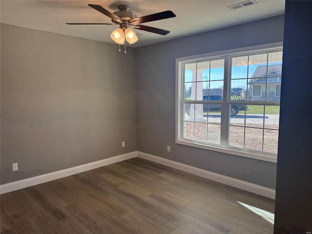 empty room with hardwood / wood-style flooring, plenty of natural light, and ceiling fan