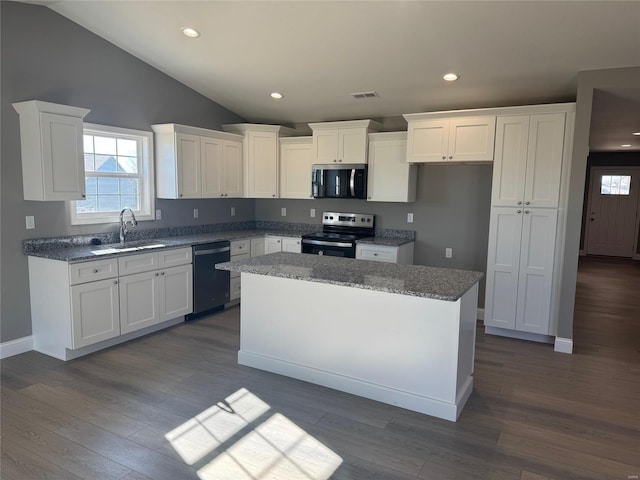 kitchen featuring appliances with stainless steel finishes, dark hardwood / wood-style flooring, sink, white cabinets, and a center island