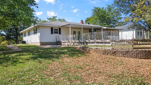 view of front of house with a front yard, a patio area, and central air condition unit