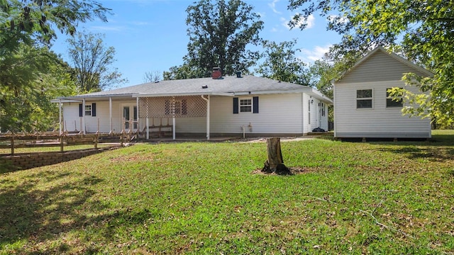 rear view of property featuring a yard and a patio area