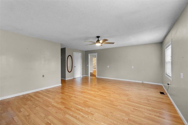 empty room featuring light hardwood / wood-style floors, ceiling fan, and a textured ceiling