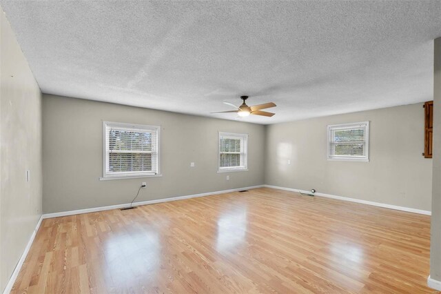 spare room with ceiling fan, light hardwood / wood-style flooring, and a healthy amount of sunlight