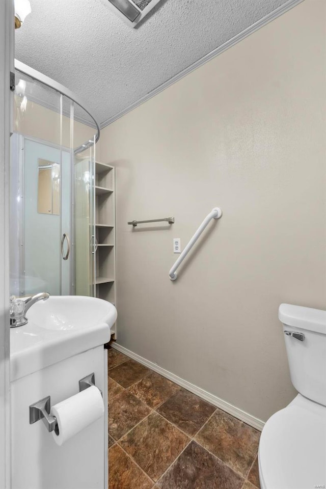 bathroom featuring a textured ceiling, sink, an enclosed shower, and toilet