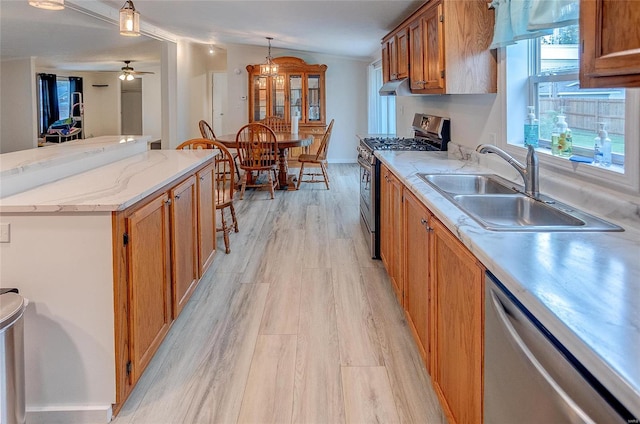 kitchen featuring ceiling fan, sink, a kitchen island, stainless steel appliances, and light hardwood / wood-style floors