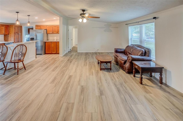 living room featuring vaulted ceiling, ceiling fan, light hardwood / wood-style floors, and a textured ceiling