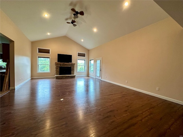 unfurnished living room with a stone fireplace, dark hardwood / wood-style flooring, and high vaulted ceiling