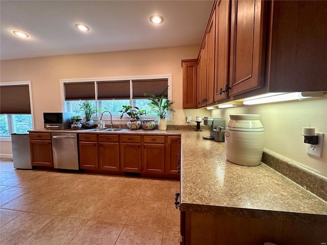 kitchen featuring light tile patterned flooring, a wealth of natural light, sink, and stainless steel dishwasher