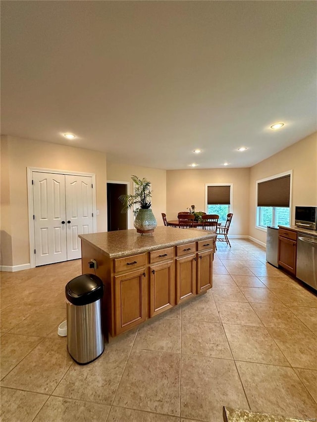 kitchen featuring stainless steel dishwasher, a center island, and light tile patterned floors