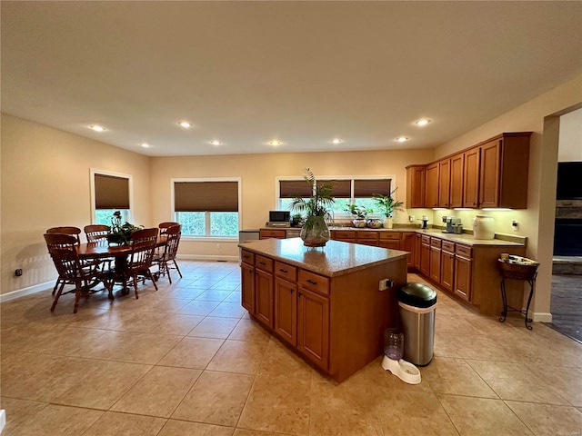 kitchen featuring a center island, light tile patterned floors, and light stone counters