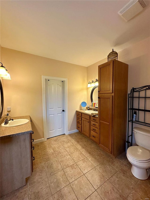 bathroom featuring tile patterned flooring, vanity, and toilet