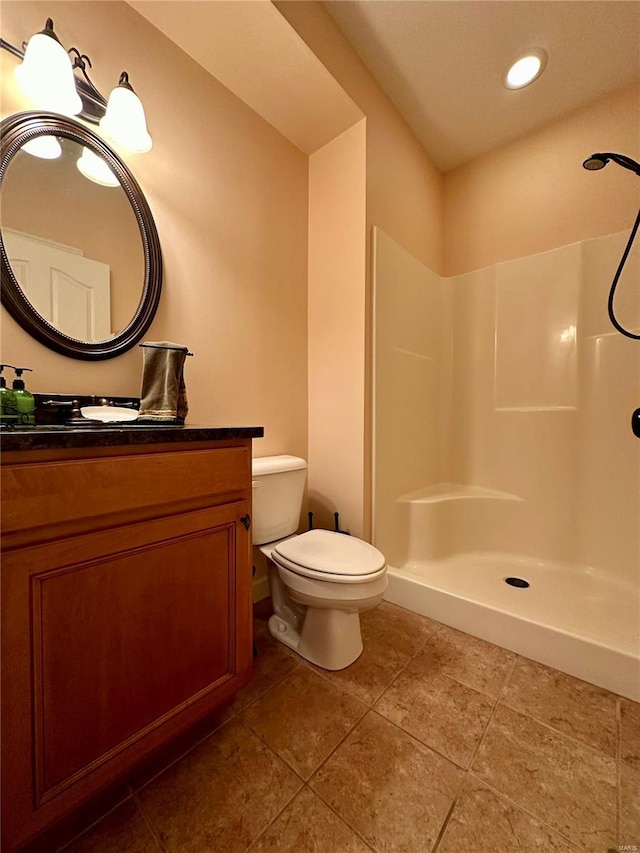 bathroom with vanity, a shower, tile patterned flooring, and toilet