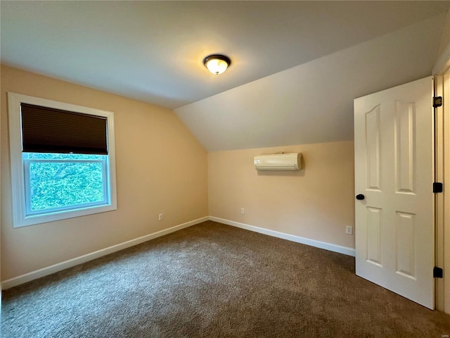 bonus room featuring dark carpet, vaulted ceiling, and a wall unit AC