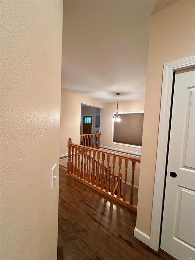 hallway featuring a notable chandelier and dark hardwood / wood-style flooring