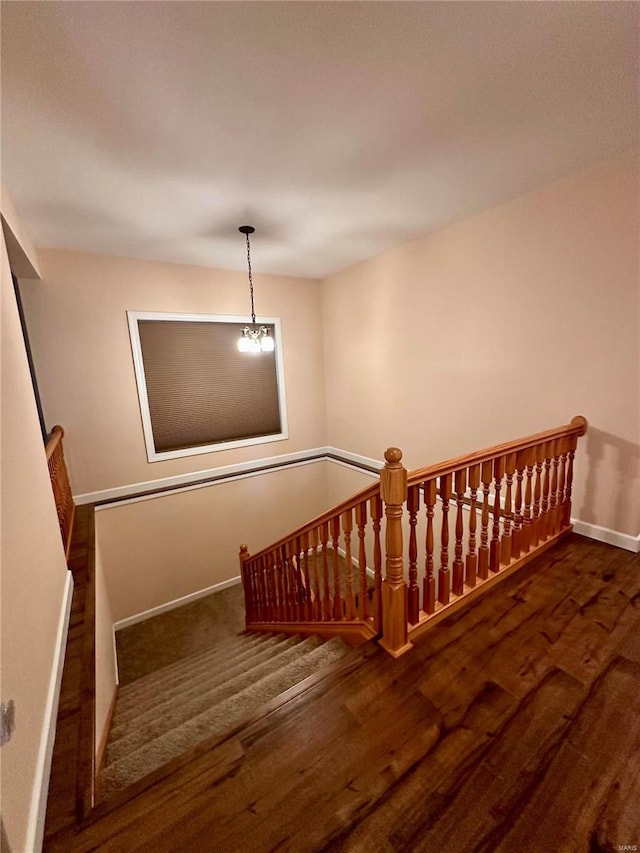 stairs featuring an inviting chandelier and hardwood / wood-style floors