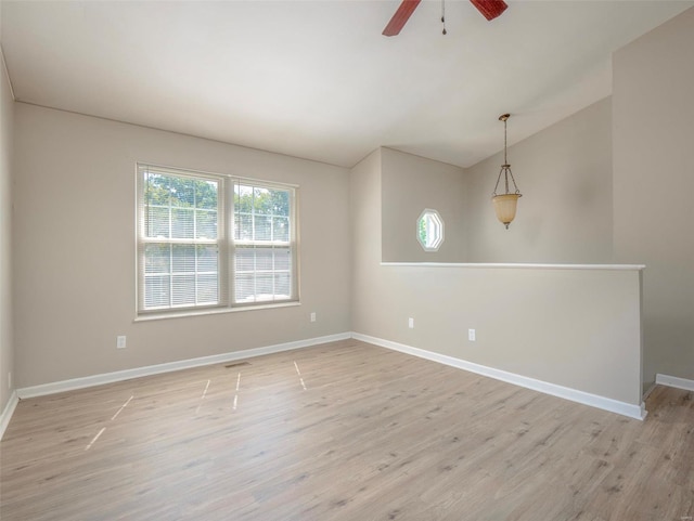 empty room featuring light hardwood / wood-style floors, lofted ceiling, and ceiling fan