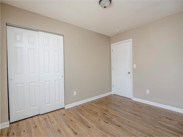 unfurnished bedroom featuring light hardwood / wood-style floors and a closet