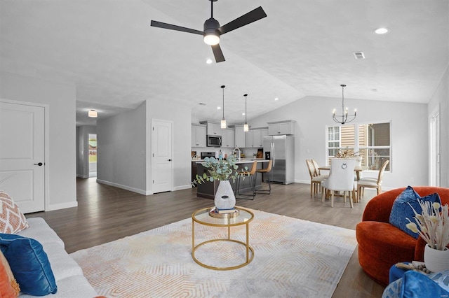 living room featuring ceiling fan with notable chandelier, lofted ceiling, wood-type flooring, and a wealth of natural light