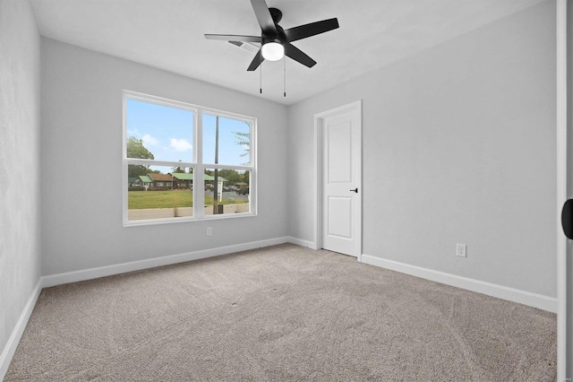 spare room featuring light carpet and ceiling fan