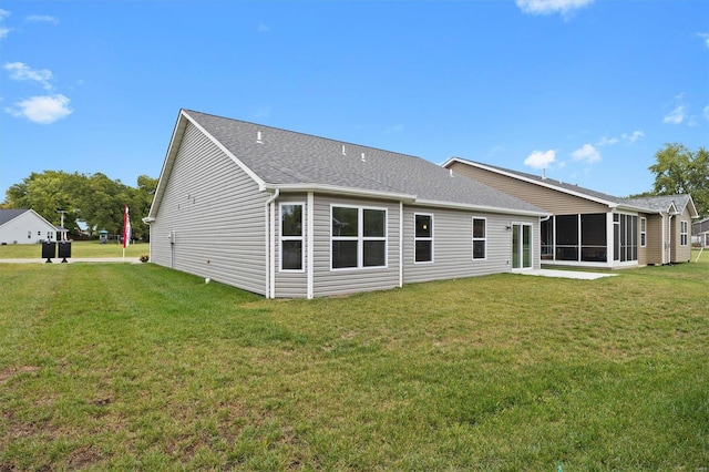 back of property featuring a yard and a sunroom