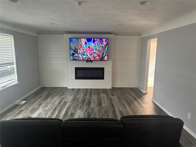 unfurnished living room featuring ornamental molding, wood-type flooring, and a fireplace