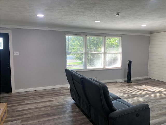 living room featuring ornamental molding, a textured ceiling, and dark hardwood / wood-style flooring